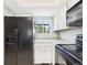 Bright kitchen with a window view features white cabinets, black appliances, and ample counter space at 2007 S Balsam St, Lakewood, CO 80227