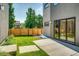 Private backyard with a wooden fence, concrete patio, and a grassy area at 3205 Quivas St, Denver, CO 80211