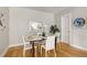 Bright dining room featuring a glass table and four white chairs at 3205 Quivas St, Denver, CO 80211