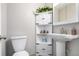 Cozy half bathroom with a pedestal sink, decorative corner shelf, and modern fixtures at 5833 S Pearl St, Centennial, CO 80121