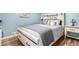 This bedroom features blue walls, wood floors, modern lighting, and built in bookshelves in the headboard at 5833 S Pearl St, Centennial, CO 80121