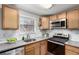 Well-equipped kitchen featuring stainless steel appliances, granite countertops, and wood cabinets at 5833 S Pearl St, Centennial, CO 80121
