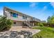 Serene backyard featuring a raised patio, lush lawn, mature trees, and a spacious elevated deck at 21690 Longs Peak Ln, Parker, CO 80138