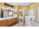 Bathroom with double sinks, vanity, tile floors, bathtub, glass shower, and doorway to bedroom at 21690 Longs Peak Ln, Parker, CO 80138