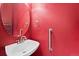 Red bathroom featuring a modern sink, round mirror, and safety bar at 21690 Longs Peak Ln, Parker, CO 80138