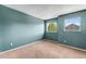 Bedroom with teal walls, carpet and two windows with bright outdoor views at 21690 Longs Peak Ln, Parker, CO 80138