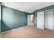 Bedroom with teal walls, carpet, a view into the hallway and a large closet with white doors at 21690 Longs Peak Ln, Parker, CO 80138