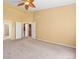 Bedroom featuring carpet floors, light-colored walls, a ceiling fan and white doors to closets and the hallway at 21690 Longs Peak Ln, Parker, CO 80138