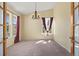 Sun-lit dining room with neutral carpet and chandelier; perfect for entertaining at 21690 Longs Peak Ln, Parker, CO 80138