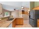 Open-concept kitchen leading to the living room, featuring stone counters and modern appliances at 21690 Longs Peak Ln, Parker, CO 80138