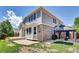 Exterior view of the home featuring a paver patio, outdoor seating area, and manicured lawn at 20394 E Colgate Pl, Aurora, CO 80013