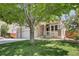 View of home with front porch framed by a large shade tree and green lawn at 20394 E Colgate Pl, Aurora, CO 80013