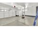 Spacious three car garage with high ceilings, featuring multiple doors, and ample storage space at 20394 E Colgate Pl, Aurora, CO 80013