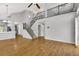 Bright living room showcasing hardwood floors, vaulted ceilings, staircase, and natural light at 20394 E Colgate Pl, Aurora, CO 80013