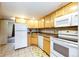 Galley kitchen with white appliances and wood cabinets at 1885 S Quebec Way # 16, Denver, CO 80231