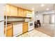 Bright kitchen featuring wood cabinets, white appliances, and a small dining area at 1885 S Quebec Way # 16, Denver, CO 80231