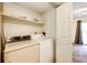 Stackable washer and dryer in a small laundry room with shelving at 1885 S Quebec Way # 16, Denver, CO 80231