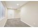 View of the finished basement with neutral carpet, white doors and a window bringing in light at 12638 James Pt, Broomfield, CO 80020