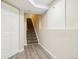View of basement stairs with vinyl flooring, leading to carpeted stairs and a white utility area at 12638 James Pt, Broomfield, CO 80020