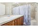 Bathroom with a double vanity sink, mirror, bath tub and a shower behind a blue curtain at 12638 James Pt, Broomfield, CO 80020