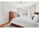 Bright bedroom features wood floors, ceiling fan, a large window, and a wood dresser at 12638 James Pt, Broomfield, CO 80020