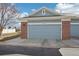 View of the home's garage with brick trim and a grey door at 12638 James Pt, Broomfield, CO 80020