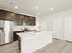 Modern kitchen with dark cabinetry, quartz countertops, and stainless steel appliances at 20972 E 66Th Ave, Aurora, CO 80019