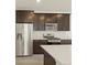 Modern kitchen with dark cabinetry, quartz countertops, and stainless steel appliances at 20972 E 66Th Ave, Aurora, CO 80019