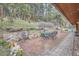 Backyard brick patio with dining set, sitting area, and surrounding greenery at 21191 Pleasant Park Rd, Conifer, CO 80433