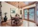 Cozy dining room with wood table, chandelier, and access to outdoor patio at 21191 Pleasant Park Rd, Conifer, CO 80433