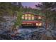 Exterior view of stone-clad home with a three-car garage and a spacious outdoor deck at 21191 Pleasant Park Rd, Conifer, CO 80433