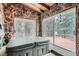 Relaxing hot tub room with natural stone walls and views of trees from the wooden deck at 21191 Pleasant Park Rd, Conifer, CO 80433