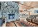 Inviting living room featuring stone fireplace and seamless kitchen integration at 21191 Pleasant Park Rd, Conifer, CO 80433
