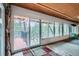 Bright sunroom featuring large windows with wooded views, carpet floors, and wood ceilings at 21191 Pleasant Park Rd, Conifer, CO 80433
