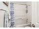 Shower and bathtub area with mounted shower head with tie-dye curtain in a modern bath at 9222 E Arbor Cir # L, Englewood, CO 80111