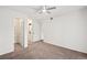 Bright bedroom features neutral carpeting, a ceiling fan, and a closet with custom shelving at 9222 E Arbor Cir # L, Englewood, CO 80111