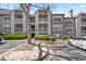 Condo exterior featuring stone accents, balconies, and manicured landscaping at 9222 E Arbor Cir # L, Englewood, CO 80111