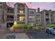 Condo exterior featuring stone accents, balconies, and manicured landscaping at 9222 E Arbor Cir # L, Englewood, CO 80111