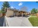 View of the brick home and backyard with putting green and covered patio area at 2090 Irving St, Denver, CO 80211