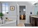 A luxurious bathroom features a soaking tub and an open doorway to the living room at 10795 Sundial Rim Rd, Highlands Ranch, CO 80126