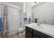 Clean white bathroom featuring a shower over tub, modern vanity, toilet, and storage cabinet at 10795 Sundial Rim Rd, Highlands Ranch, CO 80126