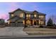 Stunning two-story home with a three-car garage, stone accents, and manicured lawn at 10795 Sundial Rim Rd, Highlands Ranch, CO 80126