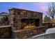 Outdoor stone fireplace featuring a stone bench and seating under a beautiful sky at 10795 Sundial Rim Rd, Highlands Ranch, CO 80126