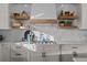 Modern kitchen featuring a marble backsplash, floating shelves, and sleek, stainless steel appliances at 10795 Sundial Rim Rd, Highlands Ranch, CO 80126