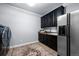 Mud room with dark cabinets, a stainless refrigerator, washer and dryer, and tile floors at 10795 Sundial Rim Rd, Highlands Ranch, CO 80126