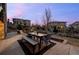 Stone patio with a dining table, outdoor seating, and a fireplace with mountain views at 10795 Sundial Rim Rd, Highlands Ranch, CO 80126