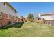 Expansive backyard showing a lush lawn, privacy fence, and mature trees at 1430 S Lima St, Aurora, CO 80012