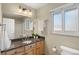 Well-lit bathroom with modern fixtures, granite countertops, a large mirror and a window at 1430 S Lima St, Aurora, CO 80012