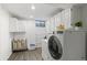 Bright laundry room with modern washer, dryer, white cabinets, and plenty of space at 1430 S Lima St, Aurora, CO 80012