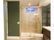 Bathroom with sliding glass shower, neutral walls, and a sleek open storage shelf at 5690 W 79Th Ave, Arvada, CO 80003
